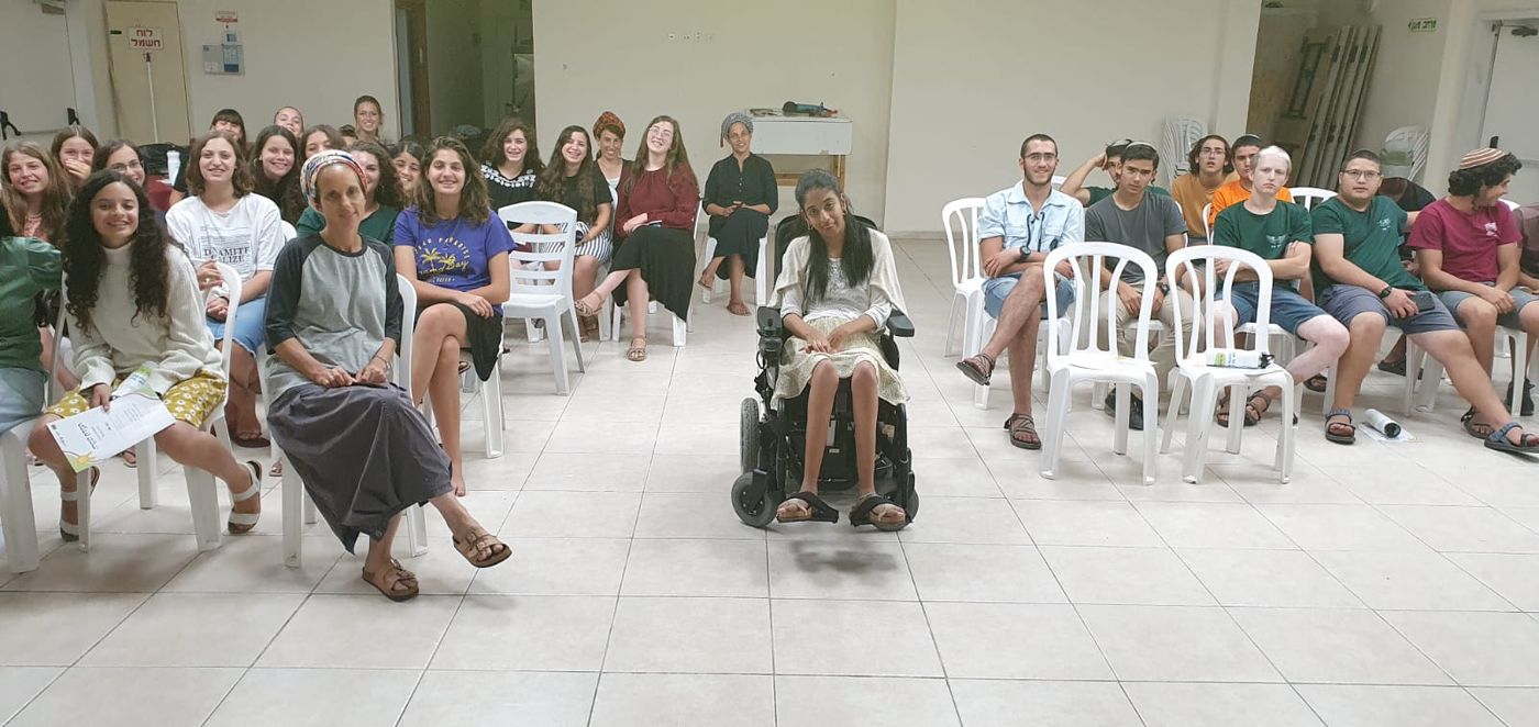 רוני עמרני מול קבוצת בני נוער היושבים במעגל ומקשיבים