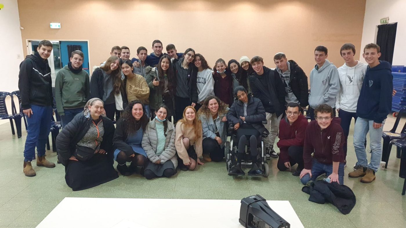 רוני עמרני בתמונה קבוצתית עם כיתת בני נוער בסיום הרצאה